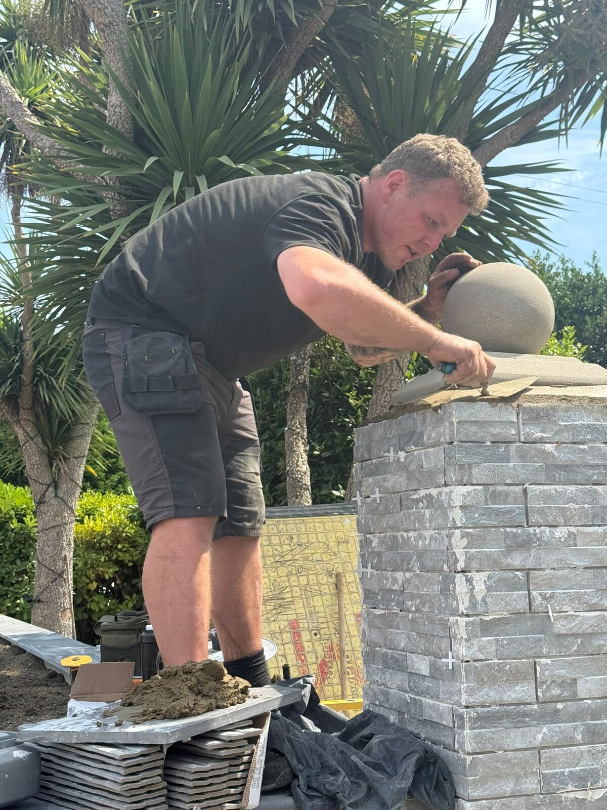 Alfie, founder of A Sterling Landscapes, finishing a natural stone pillar
